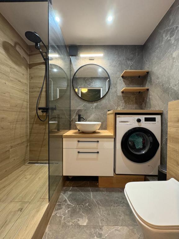 ein Badezimmer mit Waschmaschine und Waschbecken in der Unterkunft CUTE FLAT centrum in Suwałki