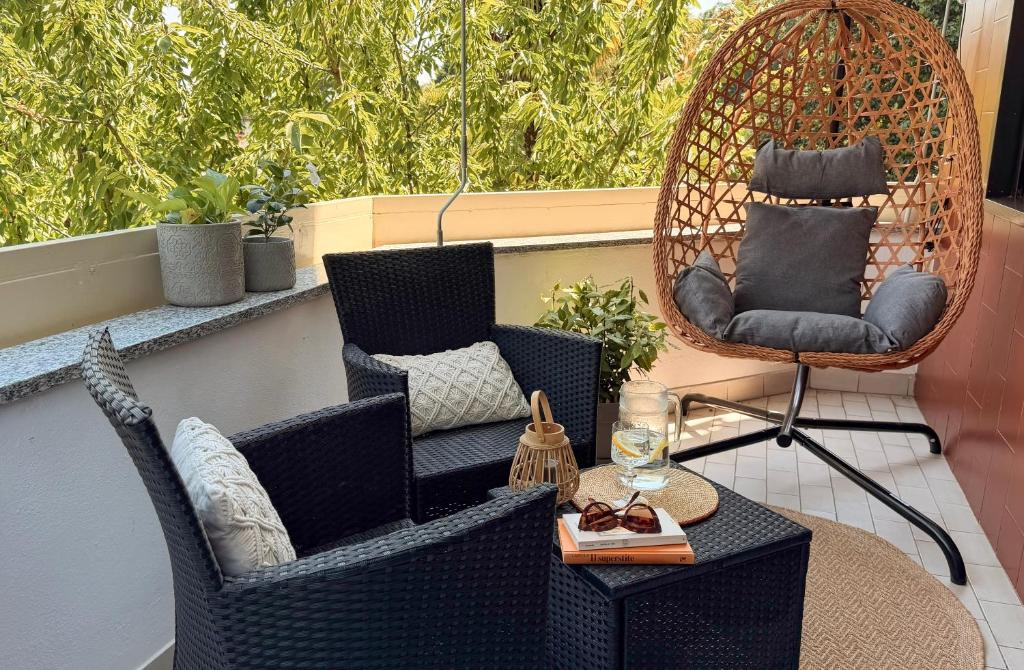 a patio with two chairs and a table and a swing at ECO - Villa Giulia in Dormelletto