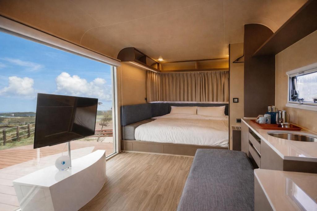 a bedroom with a bed and a large window at Bay Hill Camping Area in Magong