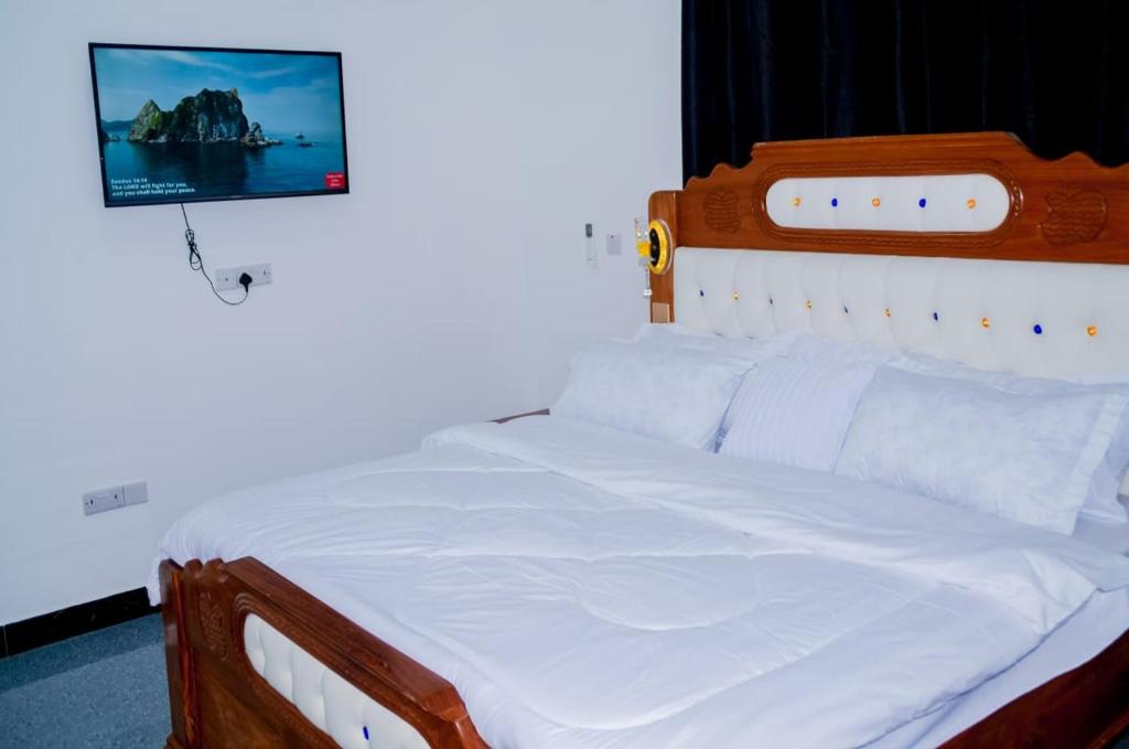 a bedroom with a white bed with a picture on the wall at Ray Infinity Suites in Paje