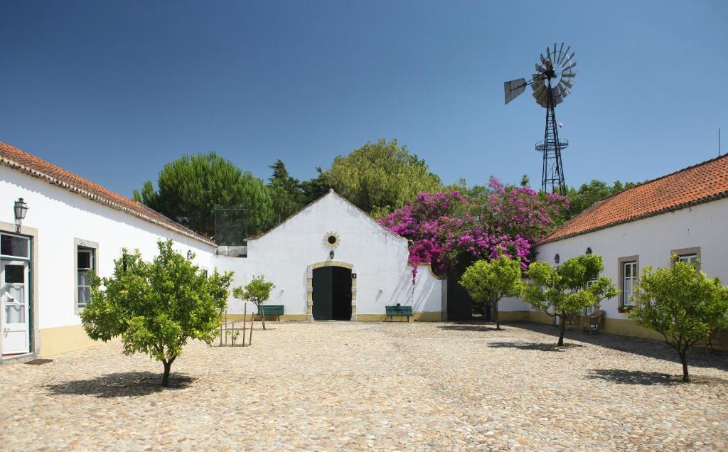 uma igreja branca com uma porta preta e árvores em Quinta Da Praia Das Fontes em Alcochete