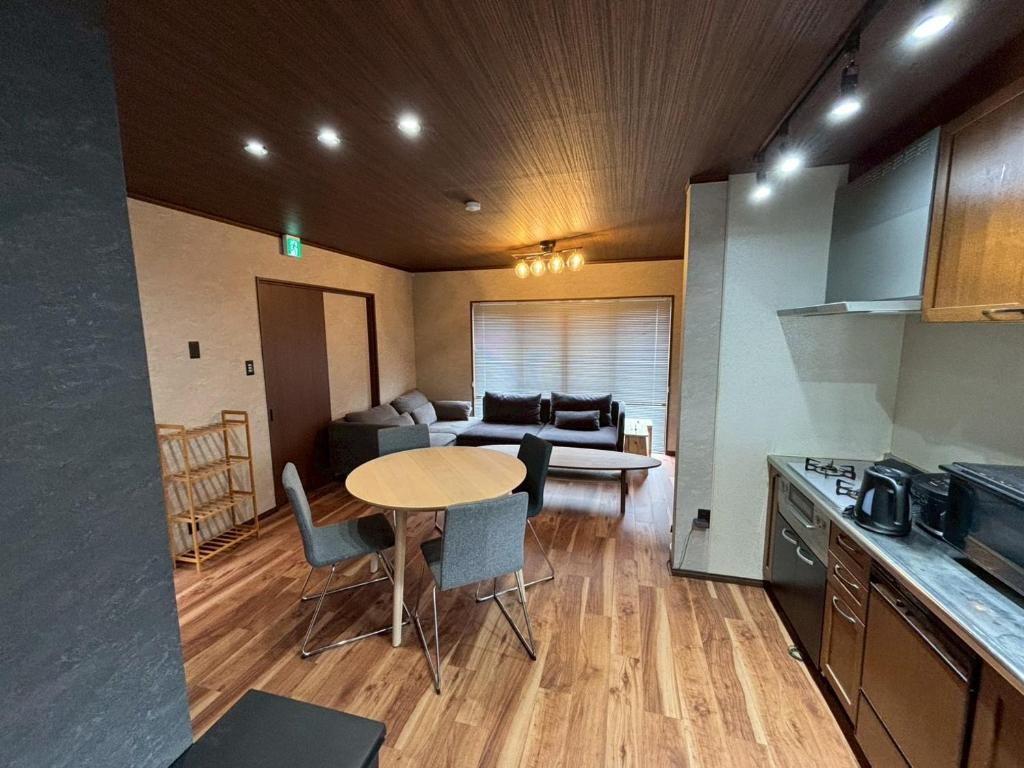 a kitchen and living room with a table and a couch at 伊勢神楽別邸 in Ise