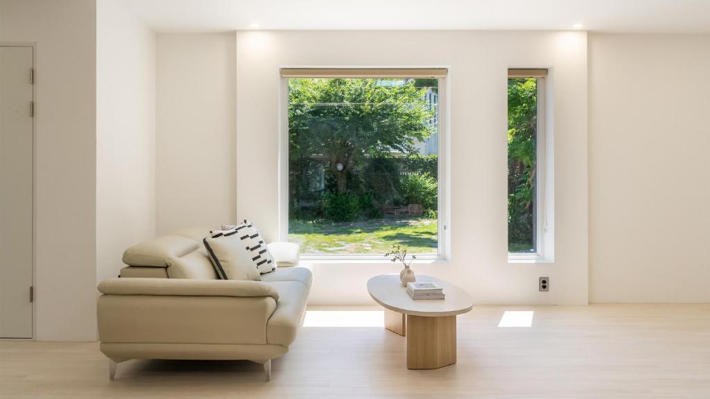 a living room with a chair and a table and a window at Pocheon Skygaram Pension in Pocheon