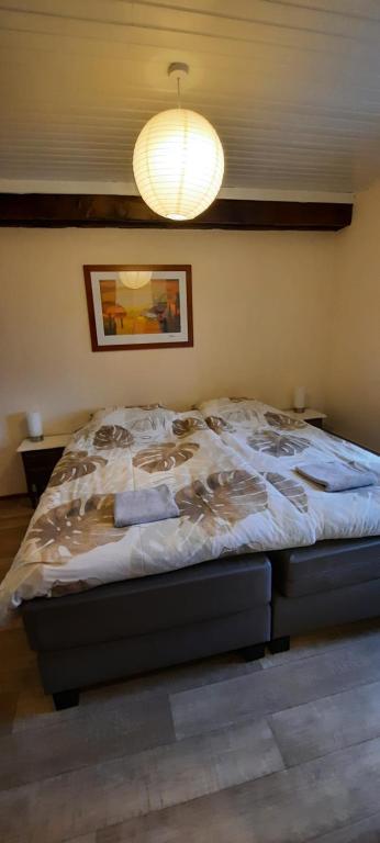 a large bed in a bedroom with a light at La Villonnière in Parnac