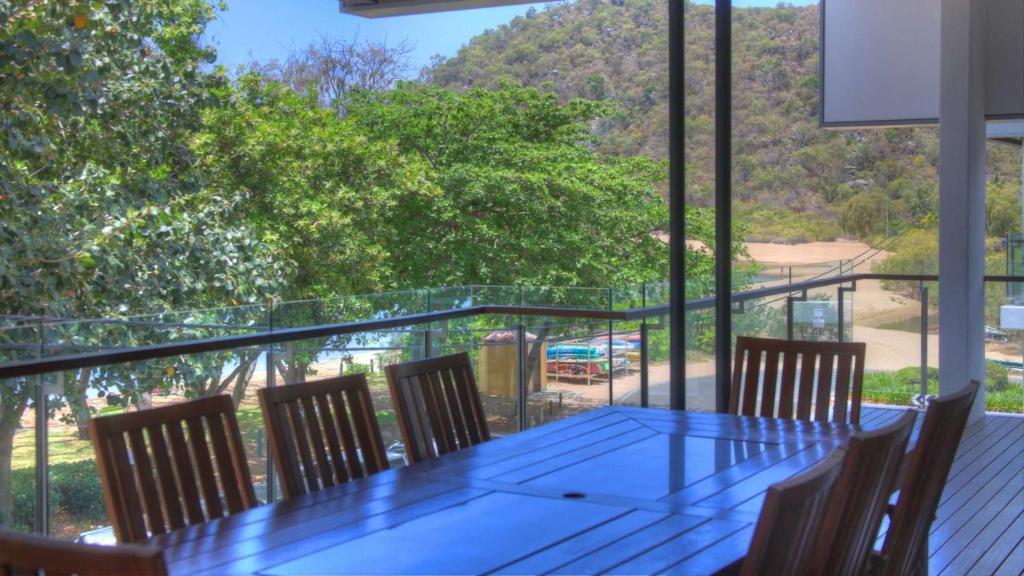 a dining room with a glass table and chairs at Maggies Beachfront Apartment 5 in Horseshoe Bay