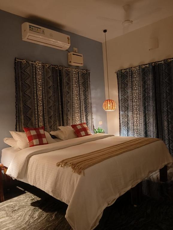 a bedroom with a large bed with red and white pillows at BrightMoon_Homestay in Pondicherry