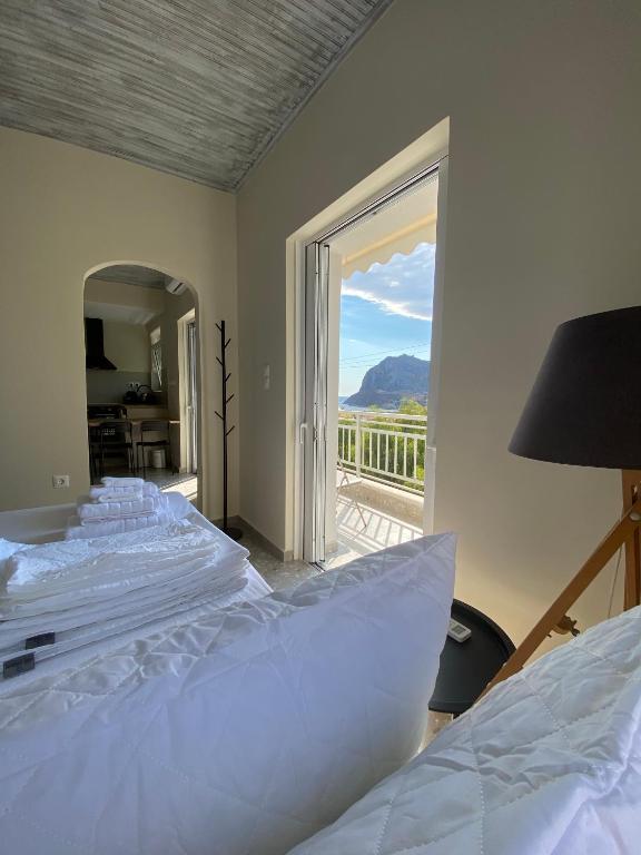 a bedroom with a large bed and a large window at Mu Caza Monemvasia in Monemvasia