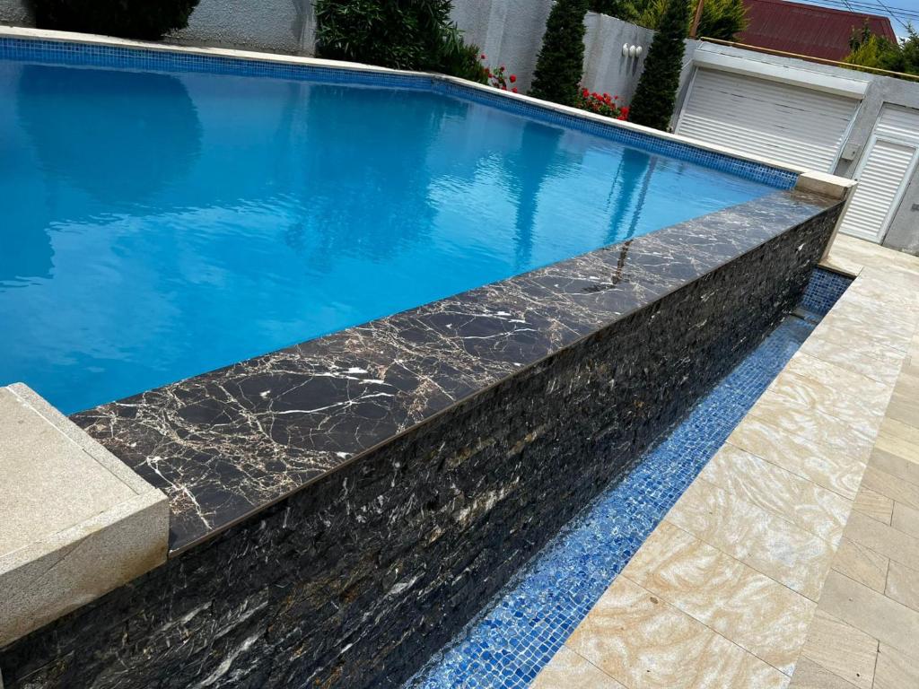 a swimming pool with a black and white marble pool at Mardakan Villa in Baku