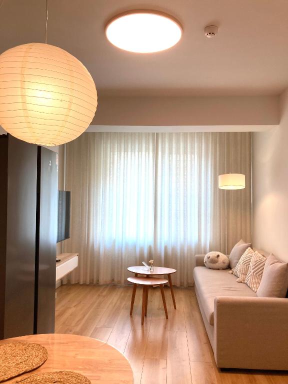 a living room with a couch and a table at Newly Renovated Japandi 1BR Near Shangri-La in Ulaanbaatar