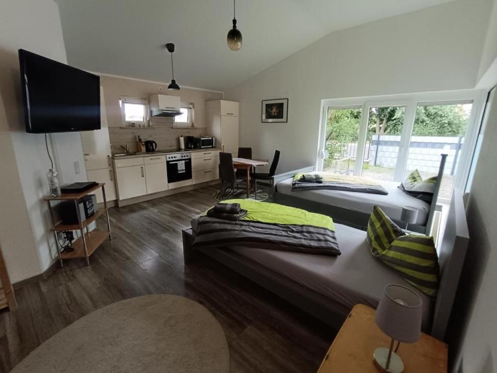 a living room with two beds and a kitchen at NEU! Ferienhaus Schwedt in Schwedt