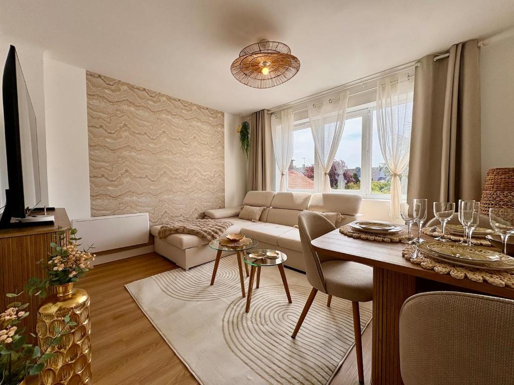 a living room with a couch and a table at Le Cocon Doré in Calais