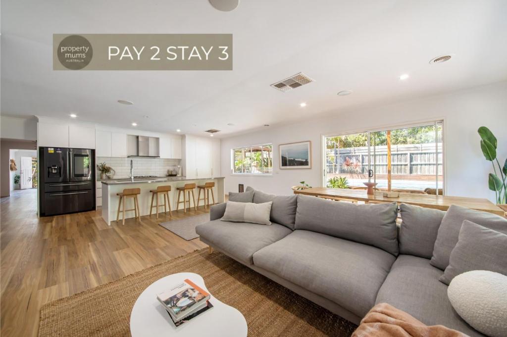 a living room with a couch and a kitchen at Malibu in Mt Martha with solar heated pool in Mount Martha