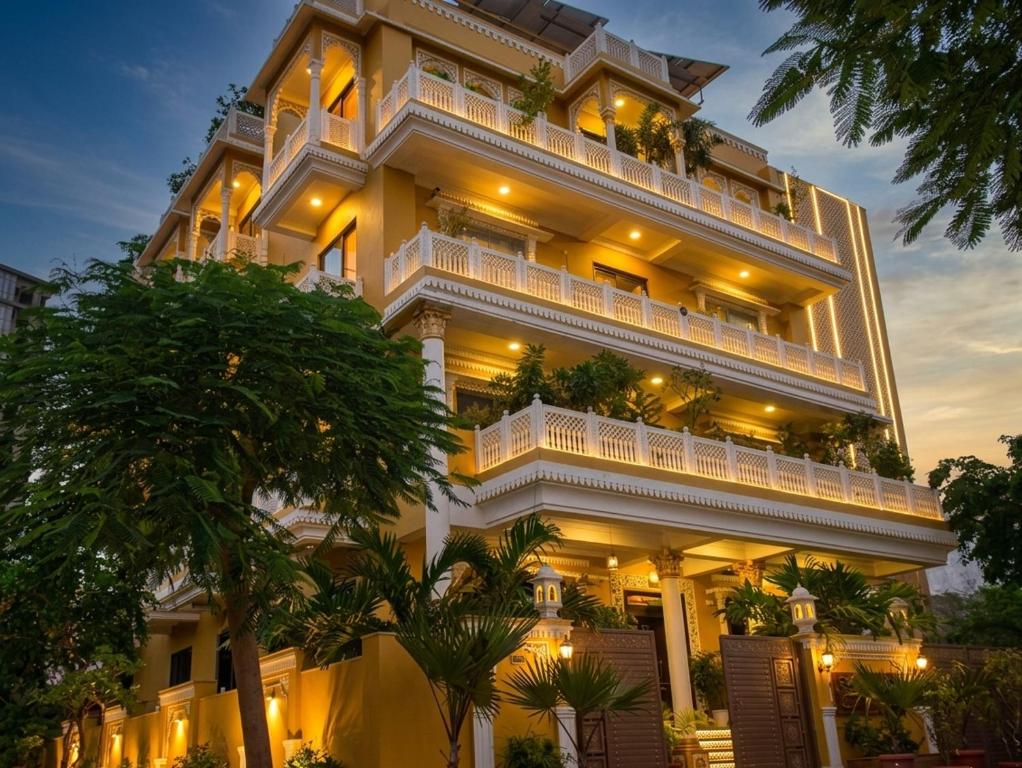 a large building with white balconies and palm trees at Jeenmount Heritage Boutique Hotel-JLN Marg in Jaipur