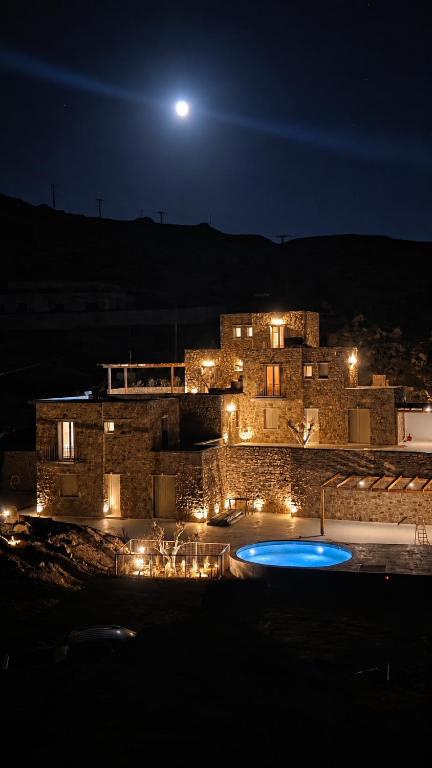 a building at night with a pool in front of it at Lucevista Mykonos Villas in Fanari