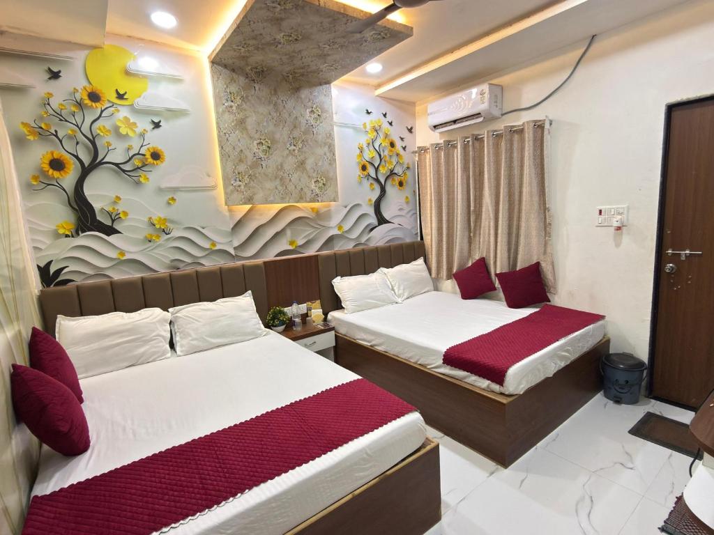 a hotel room with two beds and a painting on the wall at Shree Nagnath Residency in Ellora