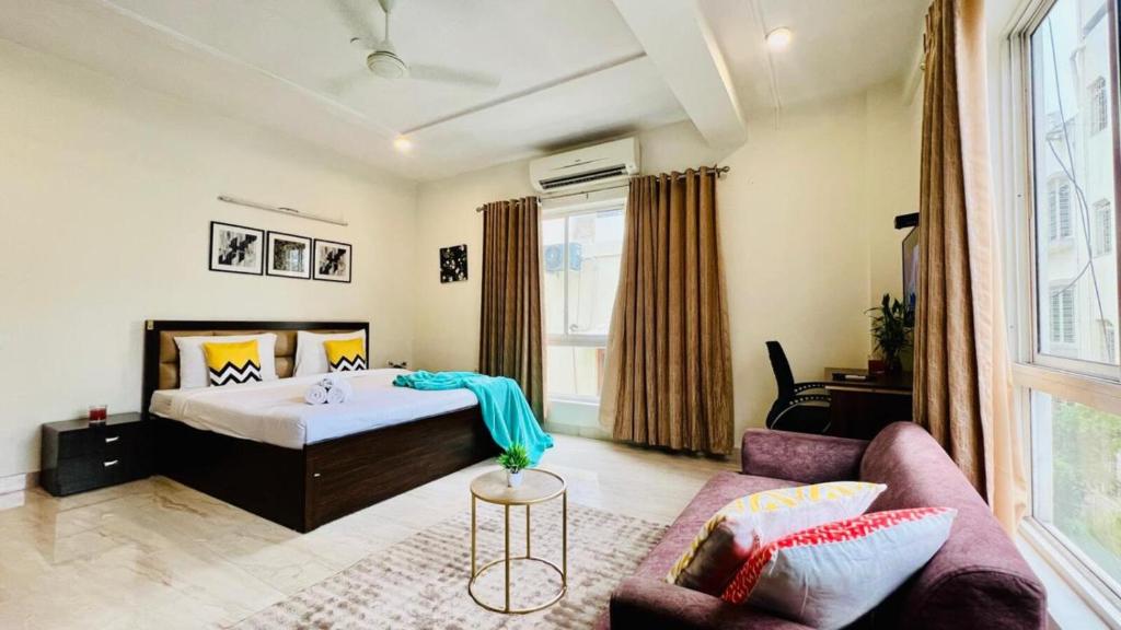 a bedroom with a bed and a couch at BluO Lake View Studio - NewTown - Terrace Garden in Kolkata