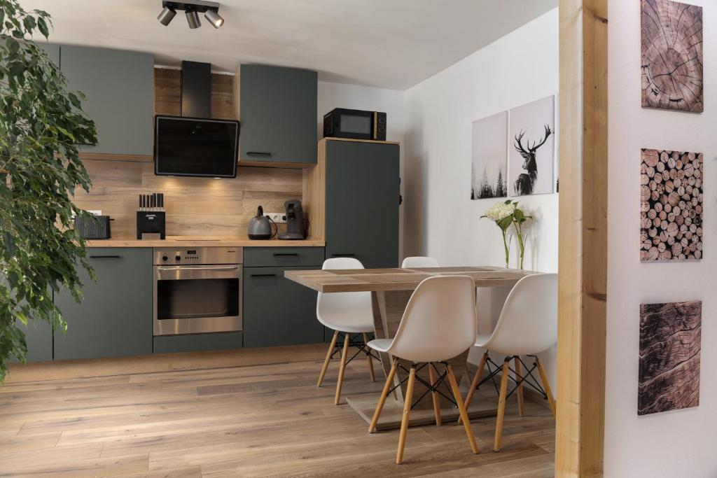 a kitchen and dining room with a table and chairs at Gemütliches Ferienhaus in Kell am Traumpfad nahe Maria Laach in Andernach