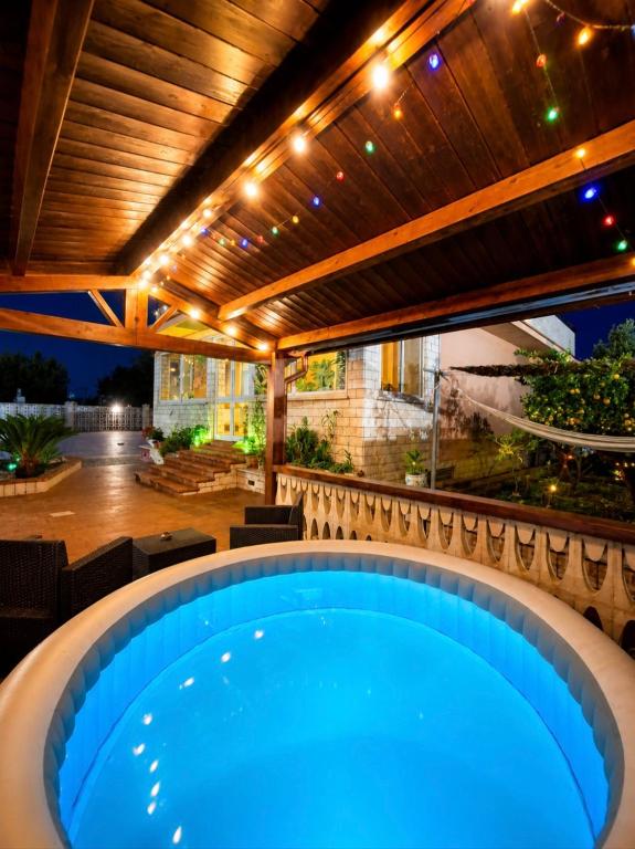 an outdoor hot tub in a patio with a wooden pergola at Villa Daisy Conversano-Polignano a Mare in Conversano