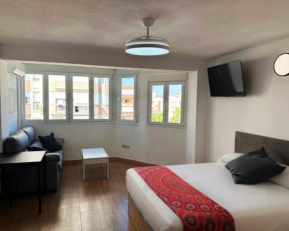 a bedroom with a bed and a living room with a couch at Brisa de Torre in Torre del Mar