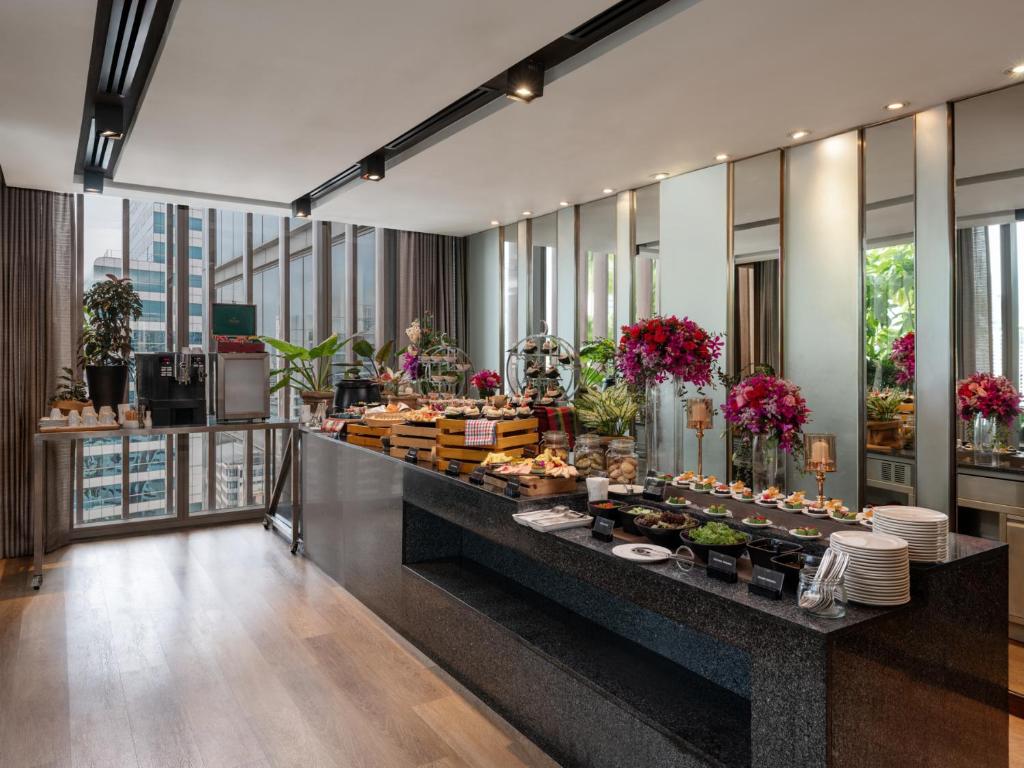 A long breakfast buffet arranged in a bright dining room with mirrored walls and city views.