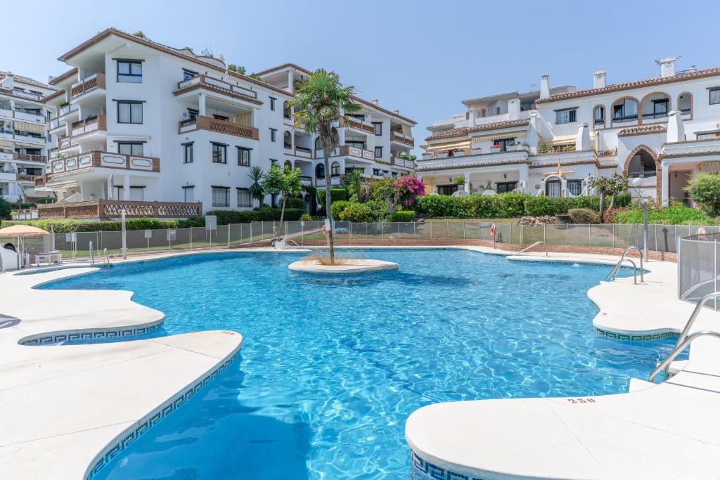 a swimming pool in front of some apartment buildings at Sunny Calahonda Park in Sitio de Calahonda