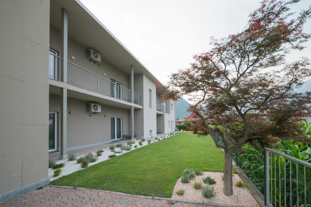 a courtyard of a building with a tree in the yard at Foresteria Pian di Spagna 2 in Dubino