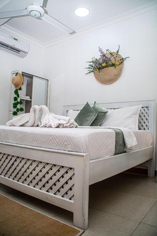 a bed in a bedroom with a basket on the wall at Mbuyu Taifa Greenview Mlandege Apartment in Zanzibar City