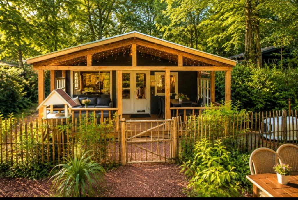 a gazebo in a garden with a fence at Chalet Bosrust met serre & privéparking Natuur nabij Maastricht in Lanaken