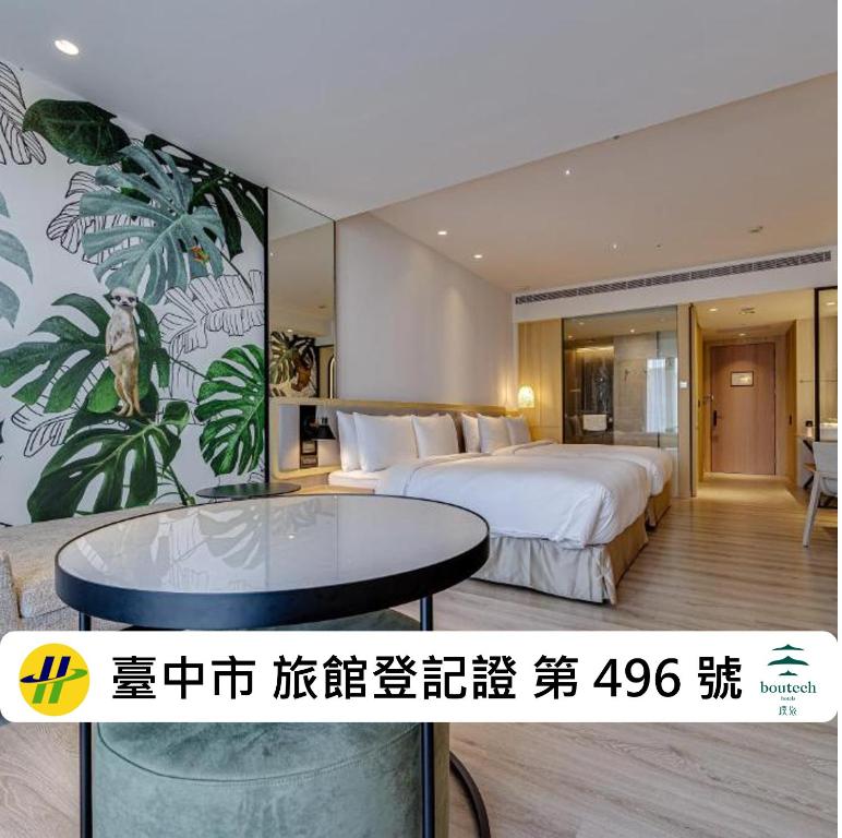 a hotel room with a large bed and a table at Boutech Wuri Village Hotel in Wuri