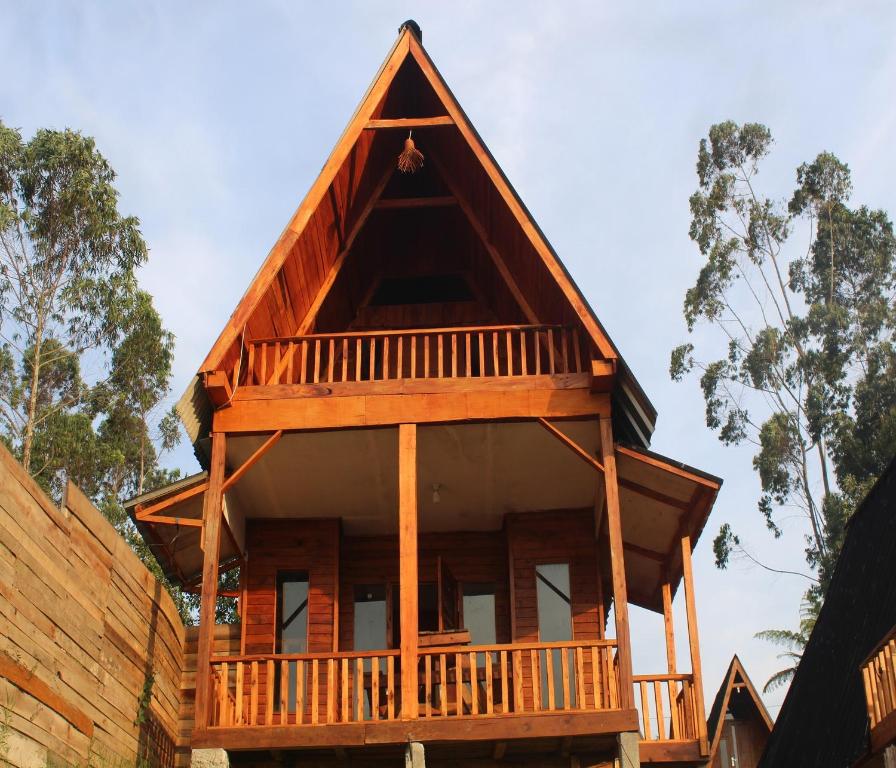 a timber house with a steep roof at Cozzy Villa Hajeka in Palayangan