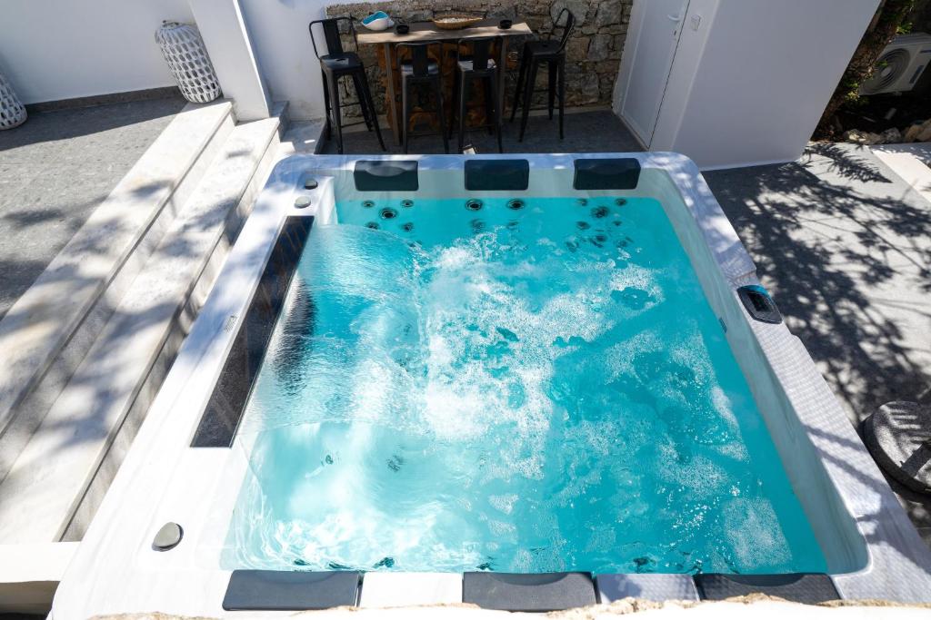 a hot tub on a patio with a table at Double Mini Suites Adults Only in Ano Mera