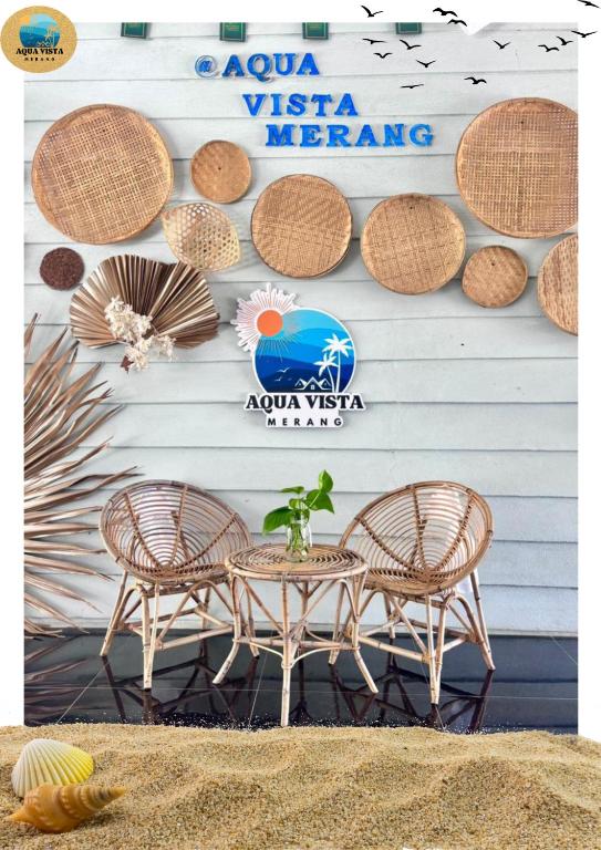 two chairs and a table in front of a wall at Aqua Vista Merang in Kampung Merang