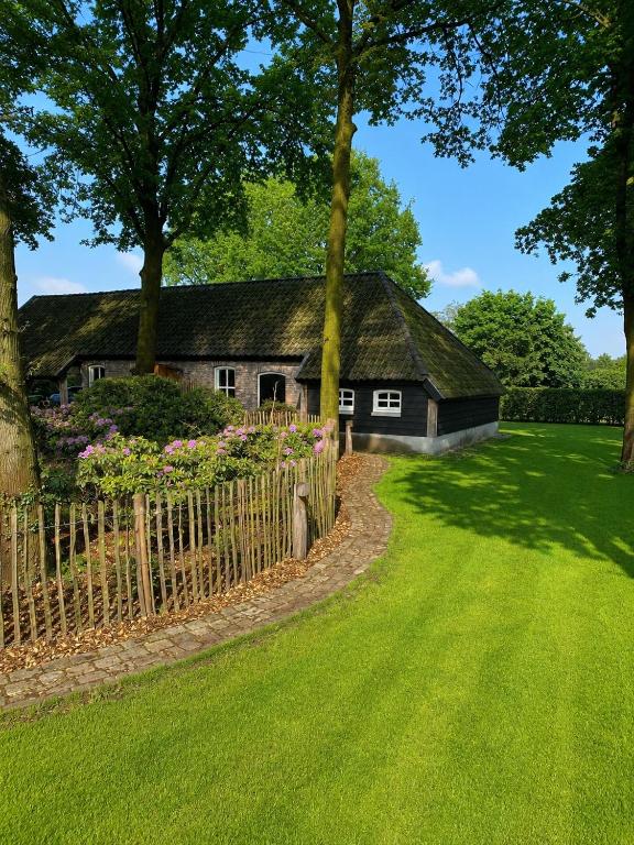 a house with a fence in front of a yard at Antoniushofke in Asten