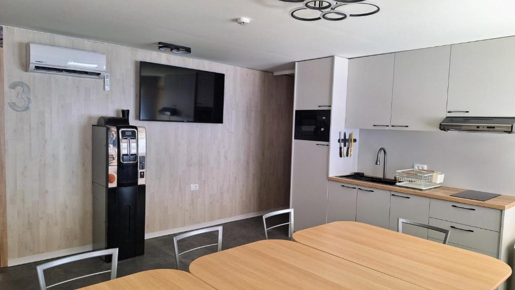 a kitchen with a wooden table and a refrigerator at Sleep House in Labin