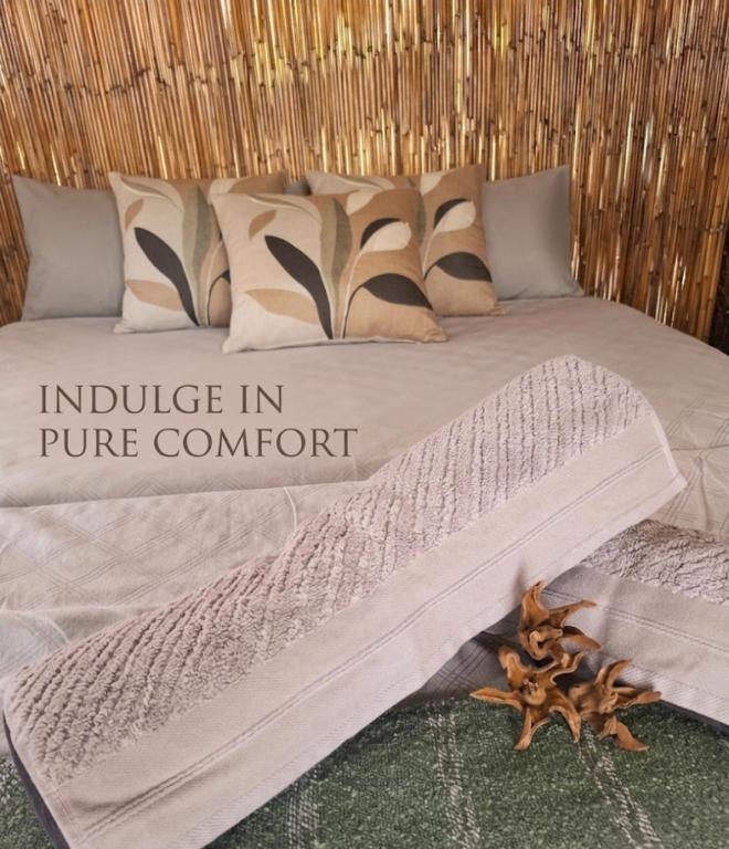 a bed with the words inclusive in pure comfort on it at Hennies HideOut in Kachikau