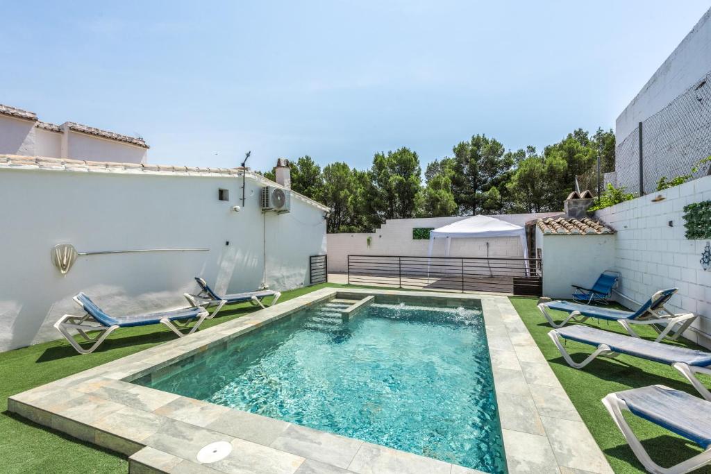 a backyard pool with chairs and a swimming pool at Casa Villazo 1 in Málaga