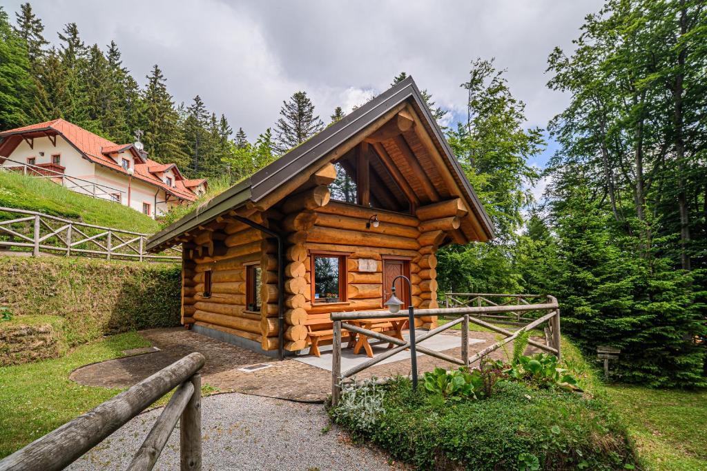 a log cabin in the woods with a house at Holiday Home Happiness in Hočko Pohorje