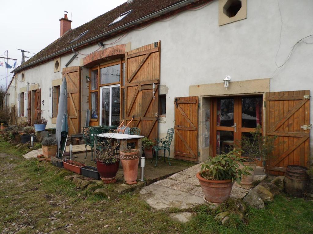 une maison avec des portes en bois et des plantes en pot devant elle dans l'établissement Le Champ Bouchon - Chambres d'hôtes, à Tréban