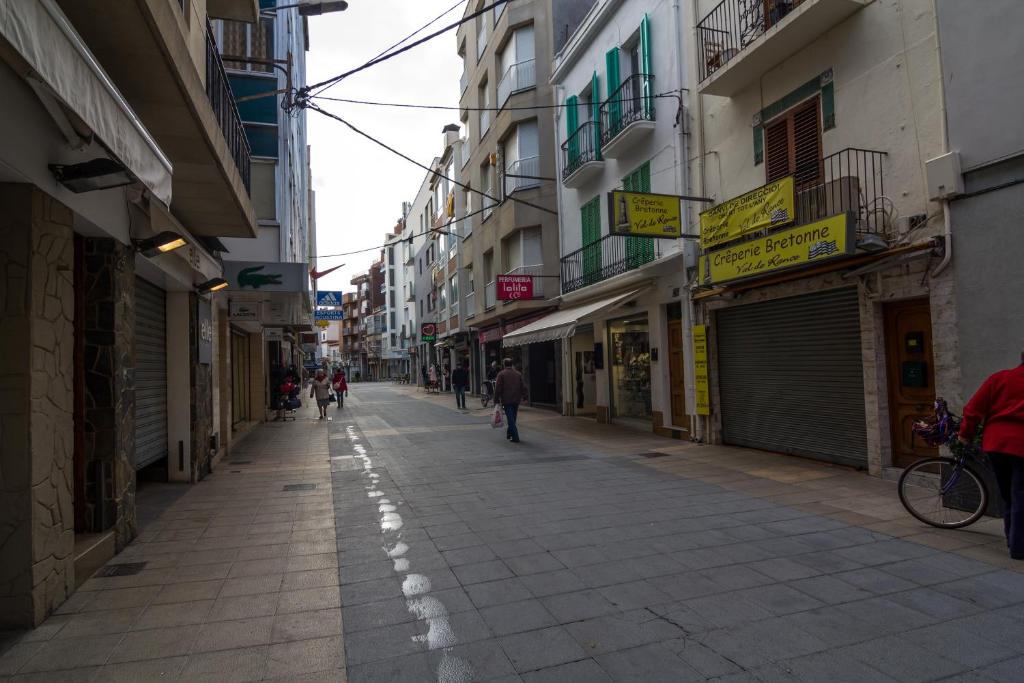 an empty city street with people walking down it at Agi Estrella de Mar in Roses