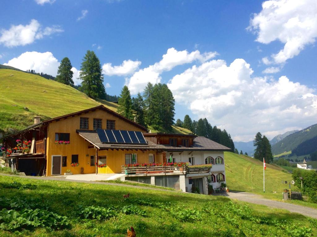 una casa con paneles solares al lado de una colina en BnB Guesthouse Lusi, en Frauenkirch