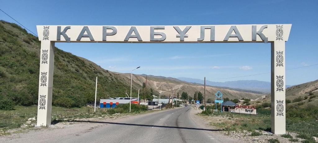 a sign that reads kappasyk on the side of a road at House Ali in Chirganak