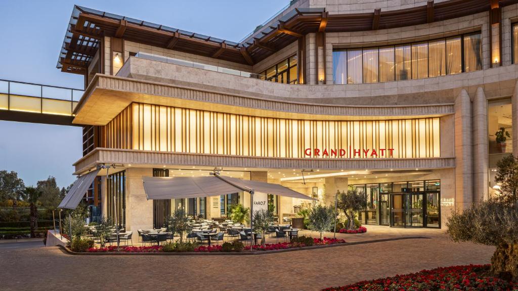 a large building with tables in front of it at Grand Hyatt Izmir IstinyePark in İzmir
