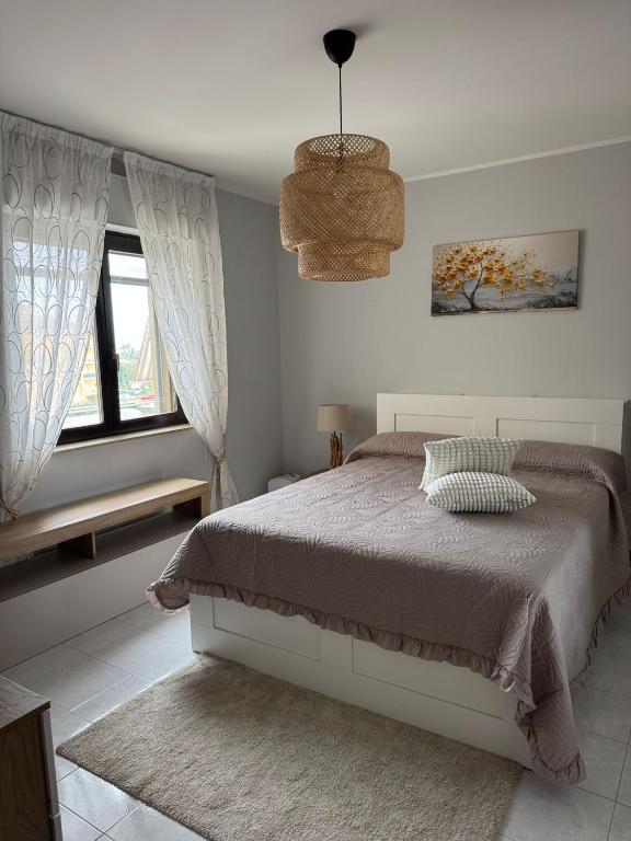 a white bedroom with a bed and a window at Domus Relax in Battipaglia