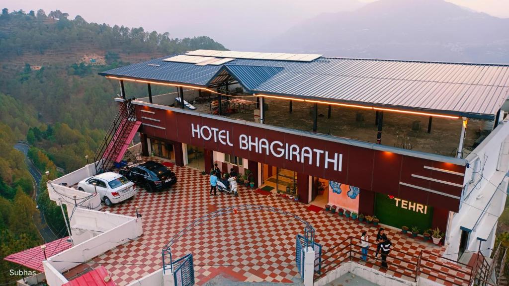 a building with a car parked in front of it at Hotel Bhagirathi in Tehri-Garhwāl