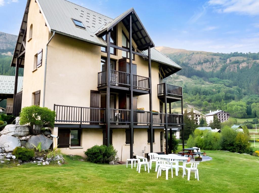 a building with a table and chairs on a lawn at Appartement spacieux à Le Monêtier-les-Bains - 75 m² avec vue in Le Monêtier-les-Bains