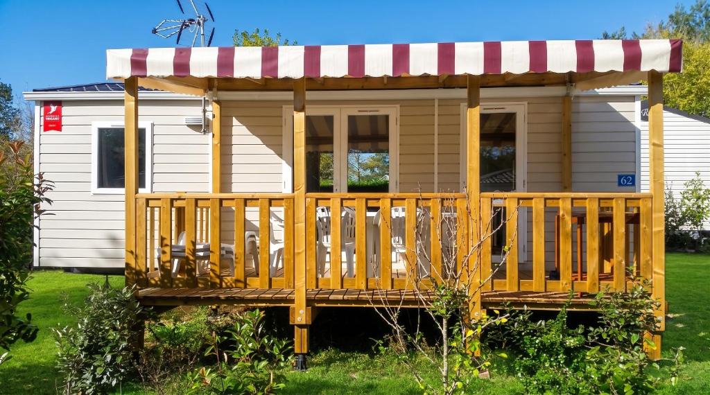 a tiny house with a porch and a awning at Bungalow charmant à Onzain avec vue sur jardin in Onzain