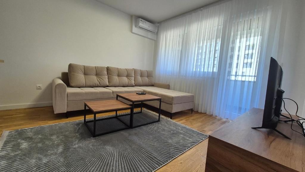 a living room with a couch and a tv at MyPlace apartmani 8 in Tuzla