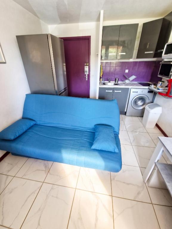 a blue couch in the middle of a kitchen at Appartement cosy à Gruissan, piscine partagée, 25 m² in Gruissan