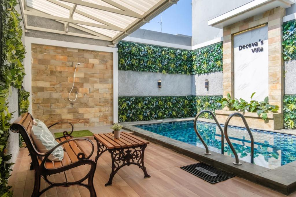 a swimming pool with two chairs and a table next to a patio at Calma Villa Panorama, Batu Malang in Batu