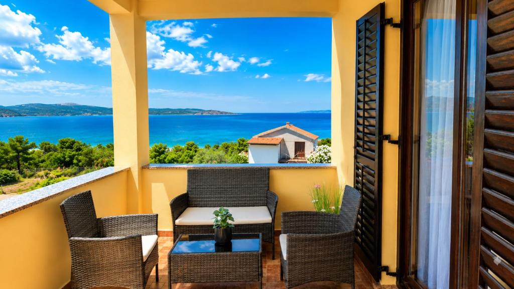 a balcony with chairs and a table and a view of the ocean at Apartment Marija in Novigrad Dalmatia